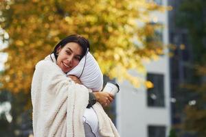 mujer joven en pijama está al aire libre en la calle. Gran ciudad foto