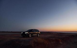 Distant view of modern black automobile that is on the coast photo