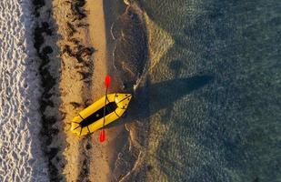 vista superior del barco amarillo que estacionó en la costa del océano durante el día foto