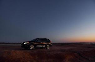 Distant view of modern black automobile that is on the coast photo