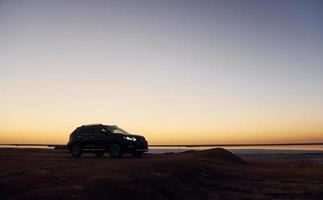 Distant view of modern black automobile that is on the coast photo