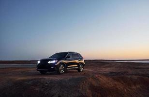 Distant view of modern black automobile that is on the coast photo