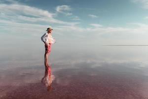 Man in hat and casual clothes walks on lake at Jarilgach island, Ukraine photo