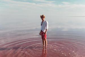 Man in hat and casual clothes walks on lake at Jarilgach island, Ukraine photo