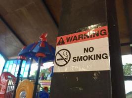 Señal de prohibido fumar en un área de juegos para niños foto