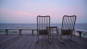 Chaise vide sur balcon avec fond de mer au crépuscule video