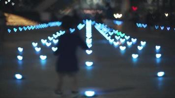 Blur hundred shape heart light on floor and tourist walk pass, conncept night light in shopping mall video
