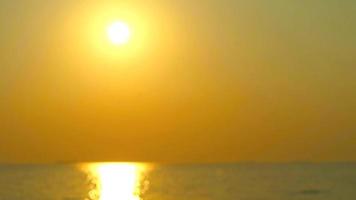 coucher de soleil doré flou sur la mer et reflet brillant de la lumière du soleil sur la surface de la mer video