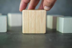 mano que sostiene el cubo de madera real geométrico