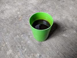 café negro caliente en una taza verde. una taza de café negro foto