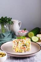 Olivier salad on a plate ingredients for its preparation on the table. Christmas snacks. Vertical photo
