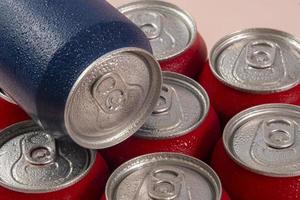 Cold red soda cans with a blue one for conceptual use photo