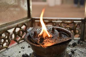 llama de lámpara en un templo para encender velas y varitas de incienso. foto