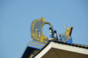 Dragon design gable apex the ornamental roof point with sky at shrine. photo