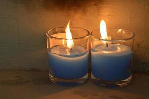 Cozy blue burning candle in 2 clear glass jar. photo