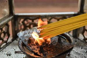 Yellow incense stick was lit by the fire of lanterns. photo