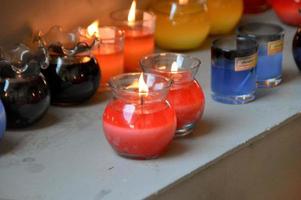 Close-up cozy red burning candle in all clear glass jar. photo