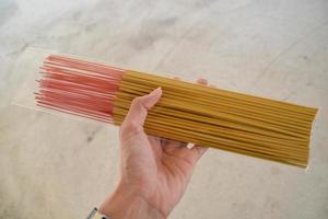 Plastic case of yellow incense in someone hand. photo
