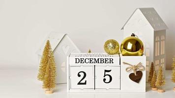 calendario de madera con fecha del 25 de diciembre y adorno dorado. concepto de navidad de oro video