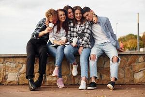 Hora de cafe. grupo de jóvenes amigos alegres que están al aire libre divirtiéndose juntos foto