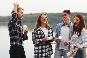 Coffee time. Group of young cheerful friends that is outdoors having fun together photo