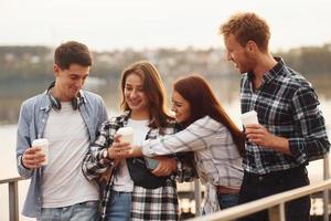 Coffee time. Group of young cheerful friends that is outdoors having fun together photo