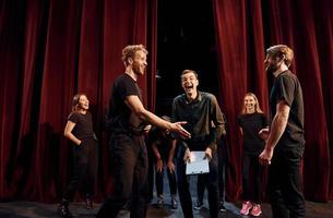 Working together. Group of actors in dark colored clothes on rehearsal in the theater photo