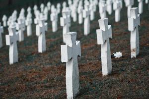 cementerio con muchas cruces conmemorativas blancas de personas sin nombre. concepción de la muerte foto