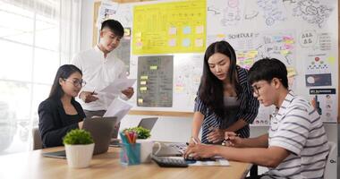 Asian woman and man team leader coach mentor talk to diverse employee in office explain strategy at corporate group meeting. Asian workers discussing together in conference room during meeting. video