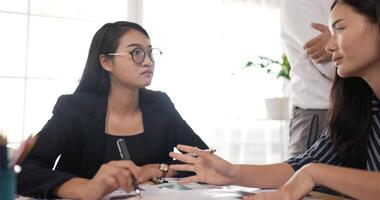 lato Visualizza di contento asiatico donna d'affari capo consulenza per donna bicchieri collega a incontro camera. allegro femmina mentore allenatore a trattativa. aziendale collega formazione a sala riunioni. video