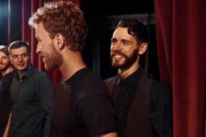 Working together. Group of actors in dark colored clothes on rehearsal in the theater photo