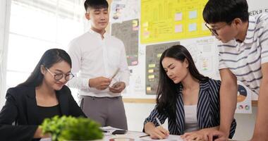 Side view of business employee explaining and editing the information in meeting room. Female and male colleagues checking document while standing at office. video