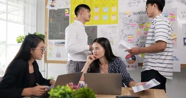 mão de uma líder de empresária asiática feliz consultando uma colega de óculos de mulher na sala de reuniões. treinador de mentor feminino alegre na negociação. treinamento de colegas corporativos na sala de reuniões. video