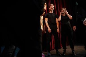 Practice in progress. Group of actors in dark colored clothes on rehearsal in the theater photo