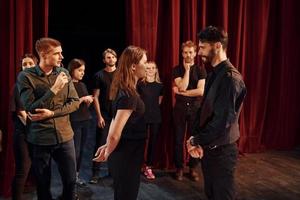 Eye contact practice. Group of actors in dark colored clothes on rehearsal in the theater photo