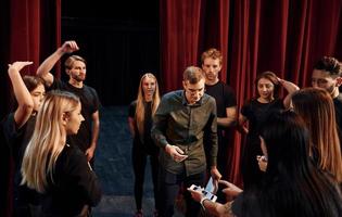 Practice in progress. Group of actors in dark colored clothes on rehearsal in the theater photo