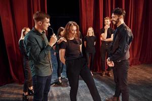 Eye contact practice. Group of actors in dark colored clothes on rehearsal in the theater photo