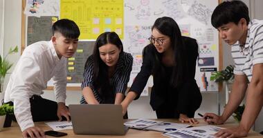 Asian woman team leader coach mentor talk to diverse employee in office explain strategy at corporate group meeting. Asian workers discussing together in conference room during meeting at office. video