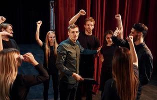 Practice in progress. Group of actors in dark colored clothes on rehearsal in the theater photo