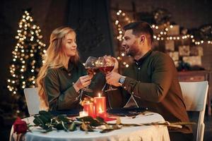 Drinks wine. Young lovely couple have romantic dinner indoors together photo