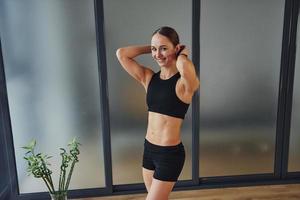 Awesome abs. Young woman in sportive wear and with slim body have fitness yoga day indoors photo