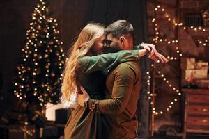 Standing and embracing each other. Young lovely couple have romantic dinner indoors together photo