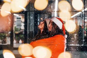 Embracing each other. Happy sisters twins spends Christmas holidays together outdoors. Conception of new year photo