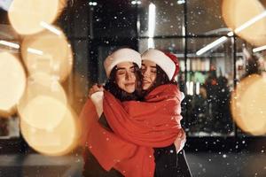 Embracing each other. Happy sisters twins spends Christmas holidays together outdoors. Conception of new year photo