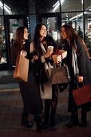 After shopping. Three cheerful women spends Christmas holidays together outdoors. Conception of new year photo