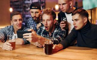 Group of people together indoors in the pub have fun at weekend time photo