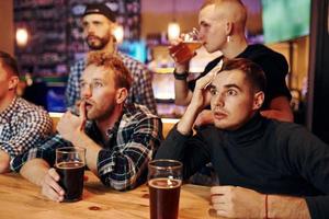 Group of people together indoors in the pub have fun at weekend time photo