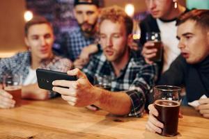 un grupo de personas juntas en el interior del pub se divierten los fines de semana foto