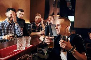 gente expresiva viendo fútbol. un grupo de personas juntas en el interior del pub se divierten los fines de semana foto