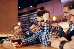 Group of people together indoors in the pub have fun at weekend time photo